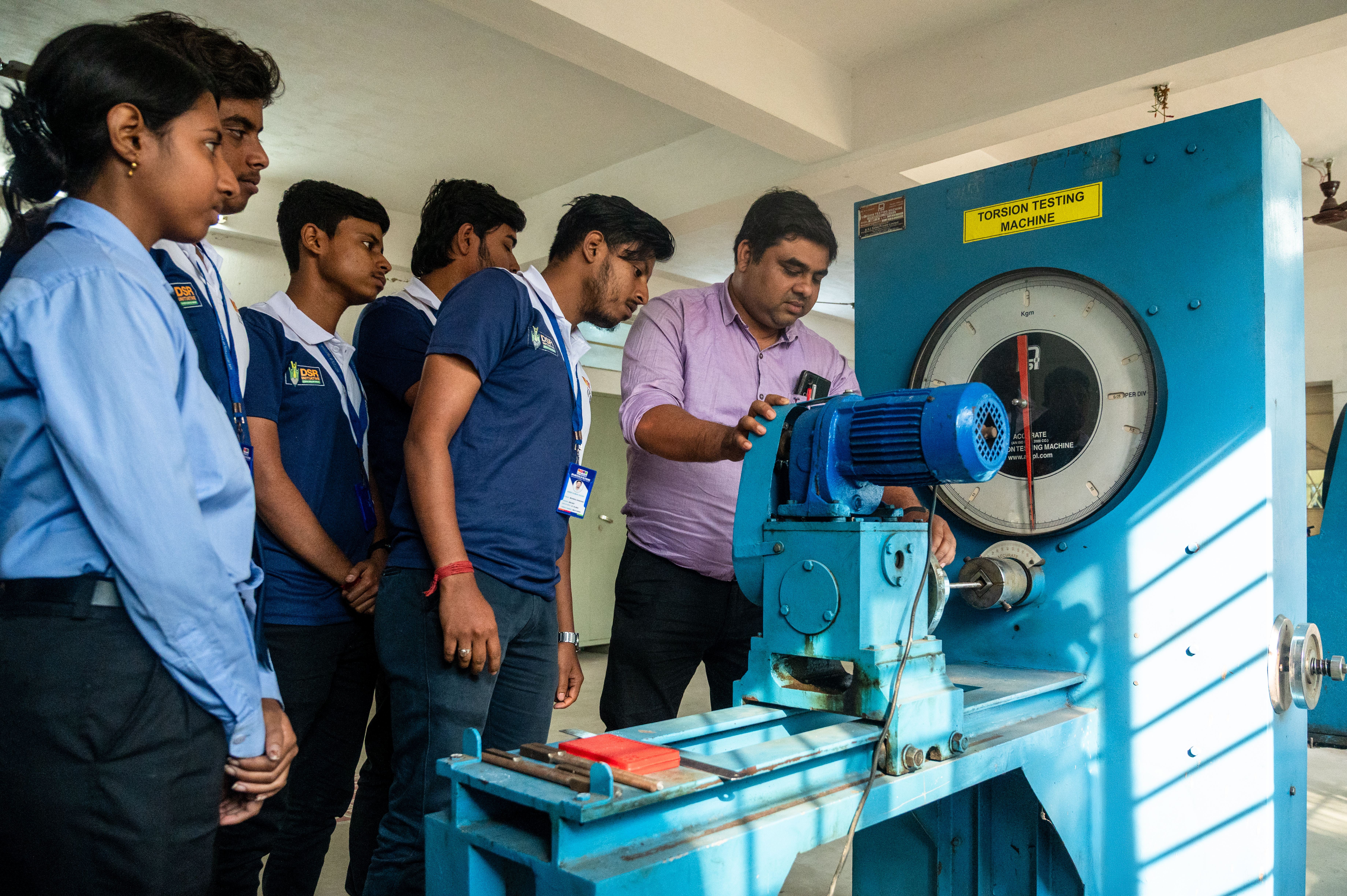 Students observing a mechanical testing machine